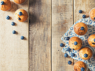 Blueberries muffins or cupcakes on wooden texture