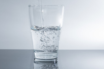 Wasser in das Glas einfüllen - sauberes Trinkwasser