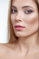 Obraz premium Fullface half profile type of a portrait of a female green-eyed blonde model with makeup on, including rose lipstick, eyshadows and contouring. Isolated on a white background.