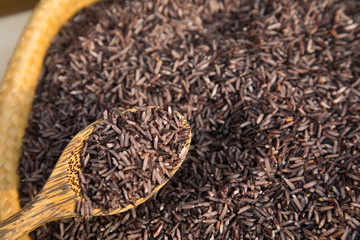 Organic Riceberry rice and wood spoon in weave basket, Food Background