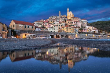 Poster Old ligurian town Cervo reflecting in water at dusk, Province of Imperia, Liguria, Italy © bbsferrari