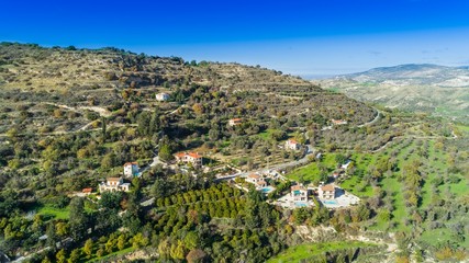 Fototapeta na wymiar Aerial bird eye view of Miliou village hills and Akamas sea at Latchi, Paphos Cyprus. View of traditional ceramic tile roof houses near Ayii Anargyri monastery nature hotel spa from above.
