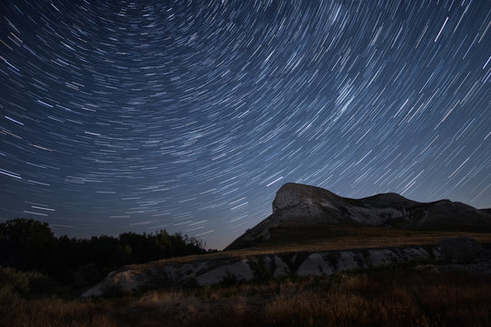 Beautiful star trails time-lapse over the hills. Polar Star at the center of rotation.Lateral light from the full moon on the chalk hills. 