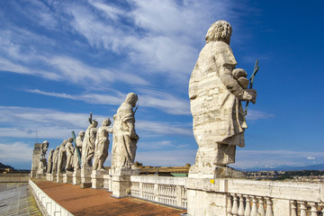 Fototapeta na wymiar Eleven statues of the saints apostles standing on the roof of Saint Peter's Basilica in Vatican City, Rome, Italy, back view