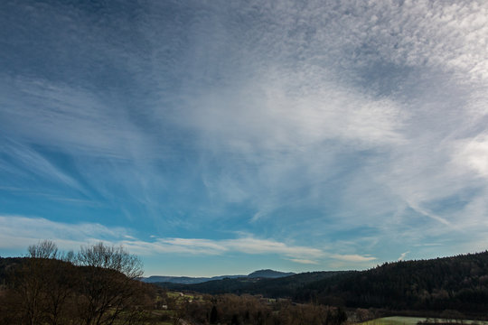 Fields, meadows, forests and white clouds in the blue sky