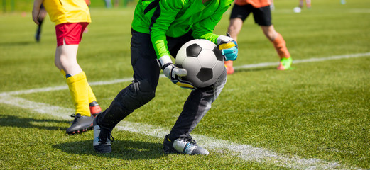 Soccer Goalkeeper Holding Soccer Ball. Soccer Goalkeeper Catching Skills. Youth Football Teams Compeeting in School Soccer Tournament