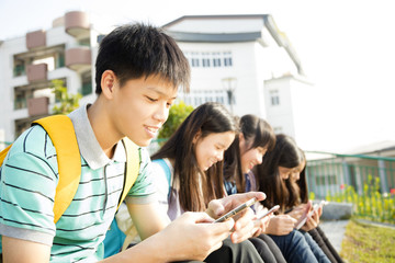 Teenage Students sitting and using smart phone