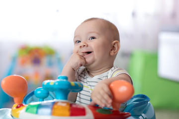 Obraz premium Baby boy sucks his fingers at home