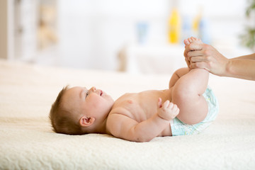 baby is enjoying massage from mother
