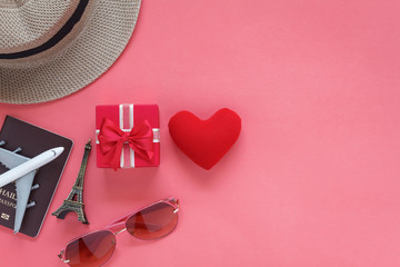 Table top view accessory of clothing women & men to plan travel in valentine's day background concept.Passport & clothes with many essential  items in holiday season.Several objects on pink paper.