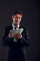 Image of banker in suit counting dollars