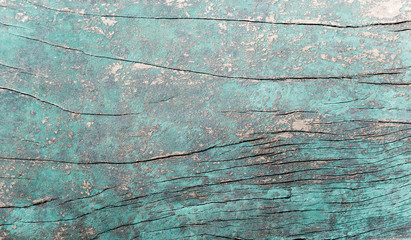 Old grungy blue green wooden surface with cracks. Text space