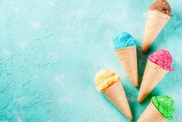  Selection of various bright multicolored ice-cream in ice cream cones - chocolate vanilla blueberry strawberry pistachio orange, on light blue sunny background, copy space top view © ricka_kinamoto