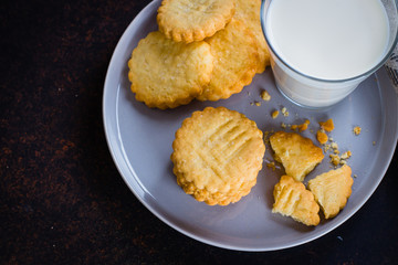 Homemade sweet sugar shortbread cookies with milk on dark stone concrete table background