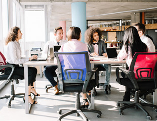 Creative working team sitting at table in office. Making plans of project.