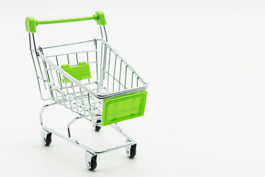 Empty mini green shopping cart on white