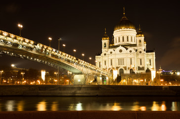 Fototapeta na wymiar Moscow, Russia. Cathedral Of Christ Savior With Bridge With Illumination By Lamps At Winter Night. Famous Christian Landmark In Russia.