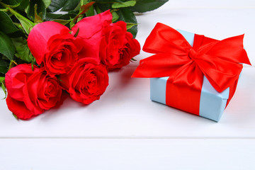 Pink roses with a gift box tied with a bow. Template for March 8, Mother's Day, Valentine's Day.
