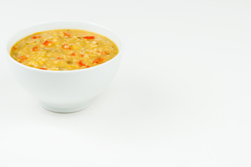 Home made lentil soup in a white bowl on a white table top with copy space