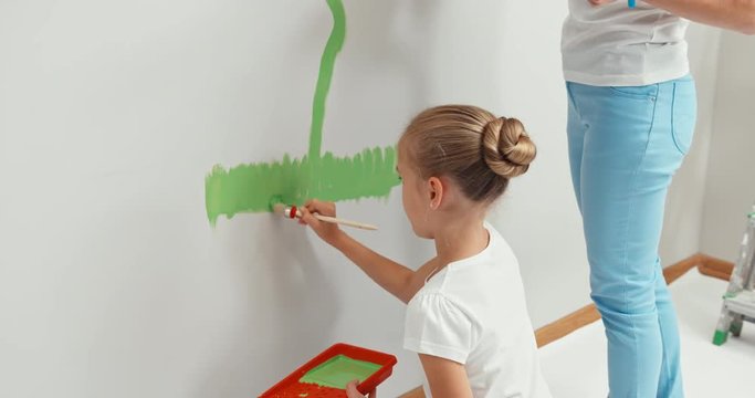 Girl painting flower on the wall in bedroom