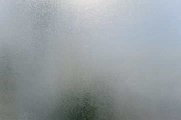 Window transparent blurred foggy glass with condensated water drops monochrome background. Vibrant...