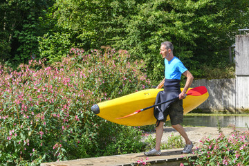 Kajakfahrer trägt sein Boot zum Einsetzort