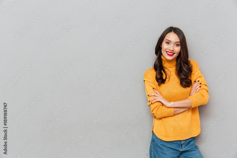 Sticker pleased woman in sweater with crossed arms looking at camera