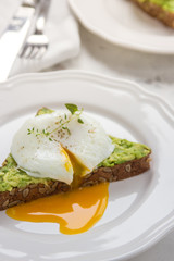 Sandwich with avocado and poached egg. Healthy breakfast