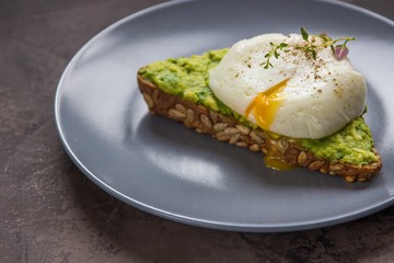 Sandwich with avocado and poached egg. Healthy breakfast