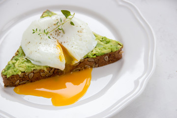Sandwich with avocado and poached egg. Healthy breakfast
