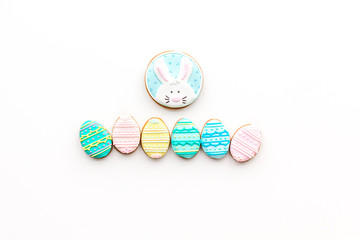 Easter background. Cookies in shape of easter bunny and easter eggs. White background top view space for text
