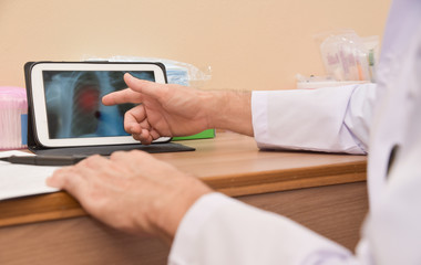 Close up Asian male Doctor hand using digital tablet computer.