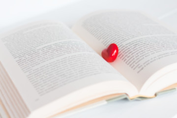 open book with small red heart, soft focus blurry, copyspace for text, concept of autumn, fall, education, nostalgic look