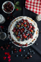 Beautiful, fruit naked cake on a dark tablecloth 