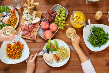 group of people eating at table with food