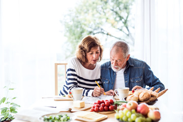 Senior couple eating breakfast at home.