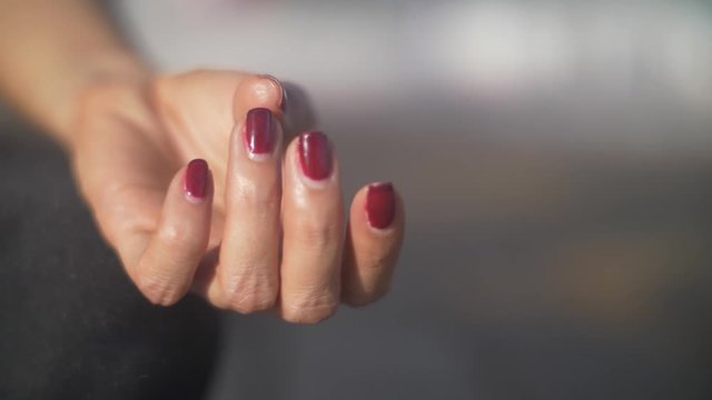 Meditative hand posture, with red fingernail polish, close up.