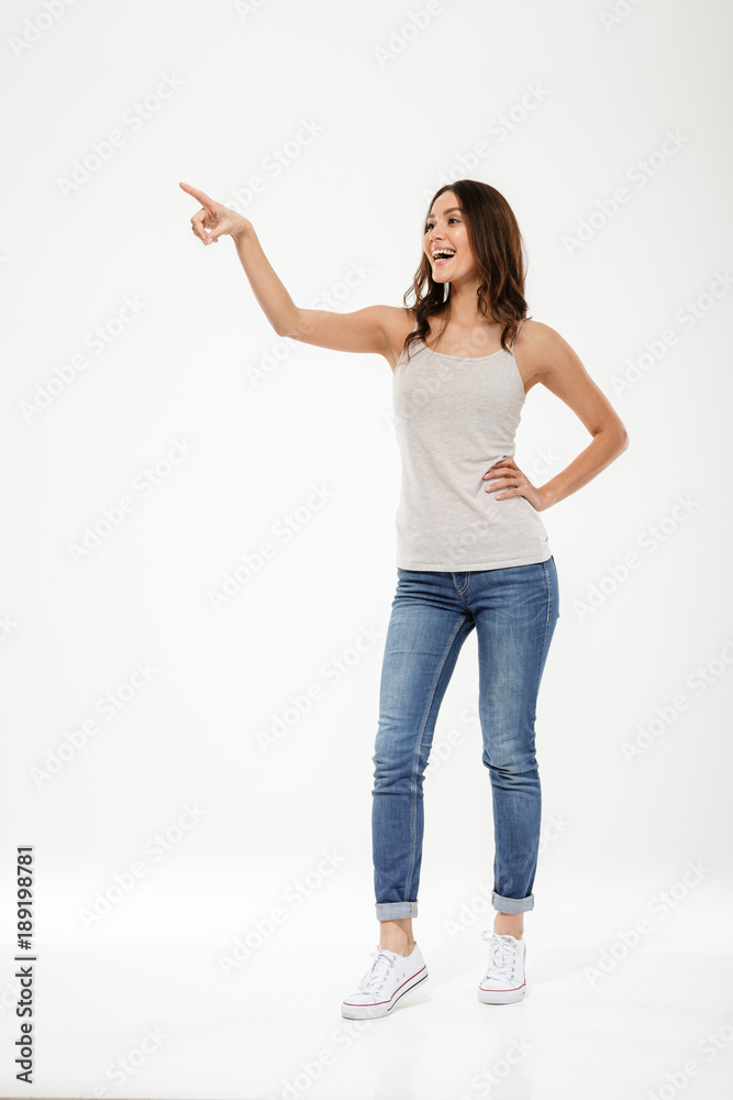 Sticker Full length image of Happy woman with arm on hip