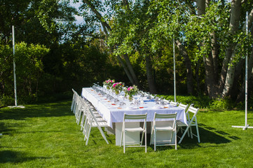 White and long wedding decorated table outdoors