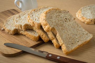 Whole wheat breads with knife on  board.