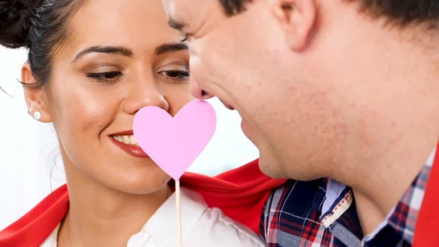 Slow motion close up on beautiful couple playing with pink papper hearts