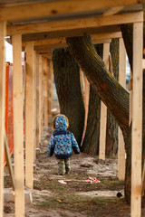 Ребёнок идёт вдоль строительного заграждения - obrazy, fototapety, plakaty