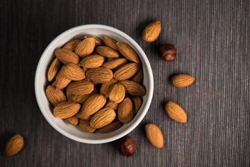 White cup filled with nuts, almonds. View from above