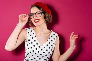 Happy ginger woman in dress and eyeglasses looking at camera