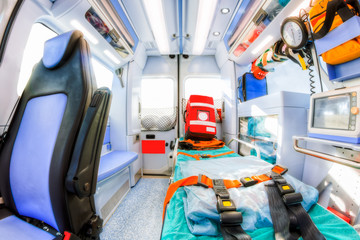 Inside the ambulance, view from the sanitary compartment. Different medical equipment and a stretcher. Selective focus, high key.