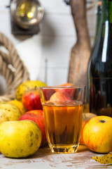 glass and bottles of cider with red and yellow apples