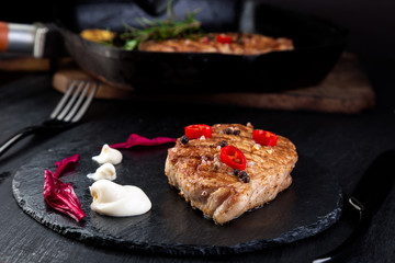 Grilled pork steak on slate plate.