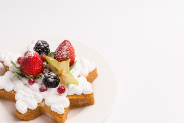 Homemade cake with whipped cream, strawberries and blackberries on white background