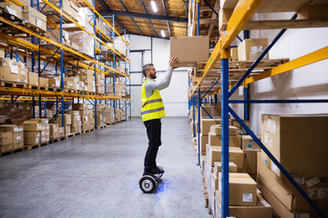 Male warehouse worker on hoverboard.