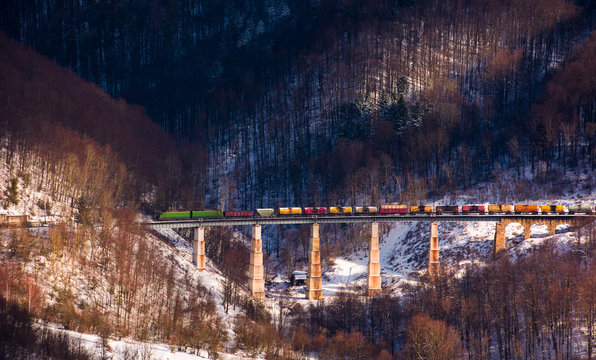 train over viaduct in winter mountains. lovely transportation scenery with snowy forested hills